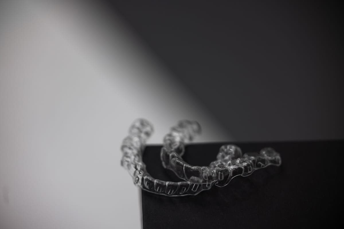 Patient holding a clear aligner during an Invisalign Clearwater consultation