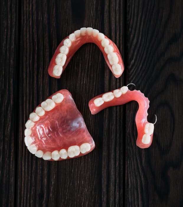 Smiling patient wearing custom dentures and partial dentures in Clearwater, FL